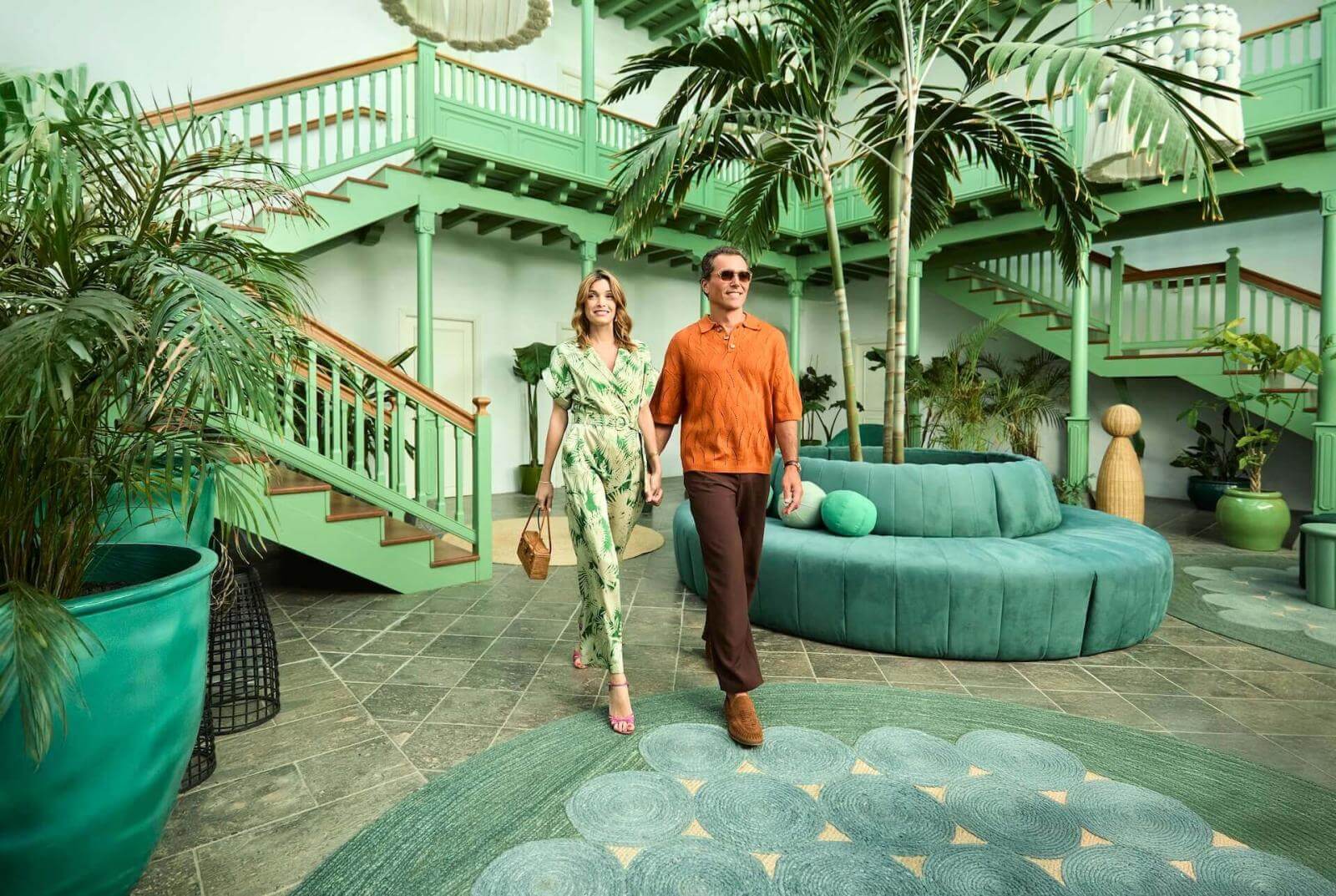 Een stel in een lounge geïnspireerd op de traditionele Canarische architectuur, met licht en tropische vegetatie.